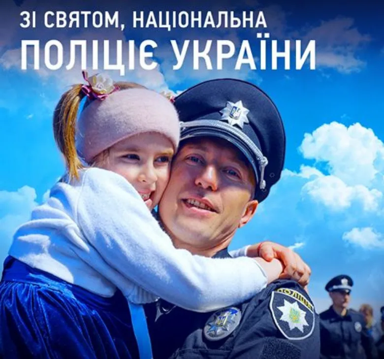 Поліцейський обіймає дитину на фоні блакитного неба.