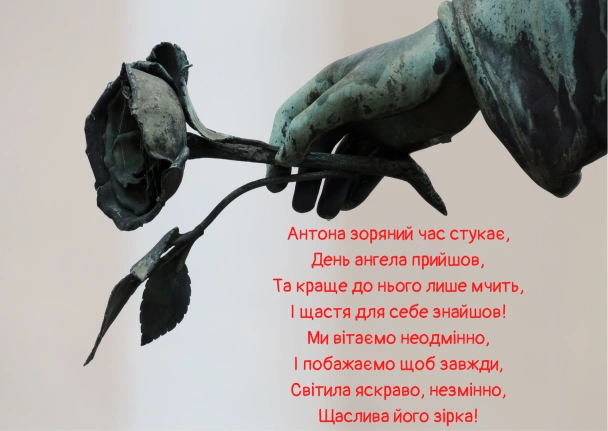 Бронзова рука тримає зів'ялу троянду поруч із привітанням Антонину.