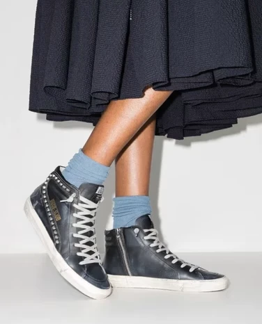Жіночі кеди Golden Goose на ногах моделі в синій спідниці