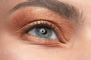 Близький план ока з сяючим макіяжем у стилі Glass Skin.