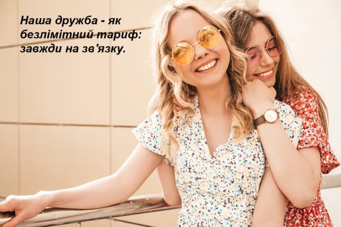 Дві подруги обіймаються на фоні сонячного дня.